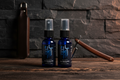 Three blue spray bottles with black labels on a gray background